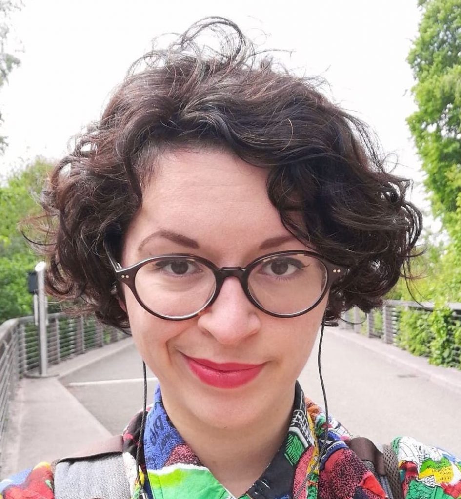 Headshot short Marine Furet is pictured smiling in Bute Park, Cardiff. She is wearing a colourful shirt.