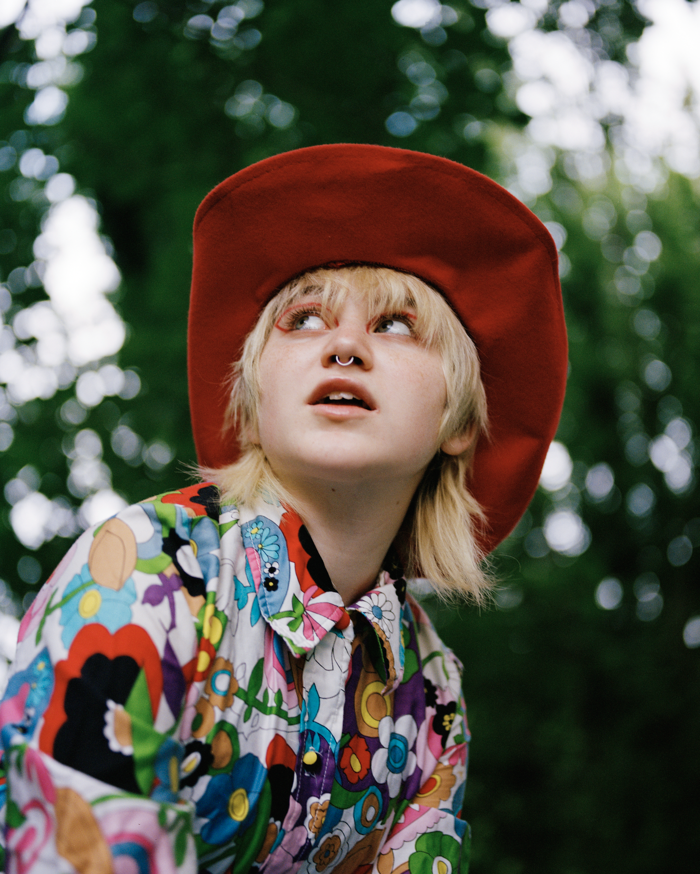 A portrait of Casper James wearing a colourful shirt and a red cowboy hat