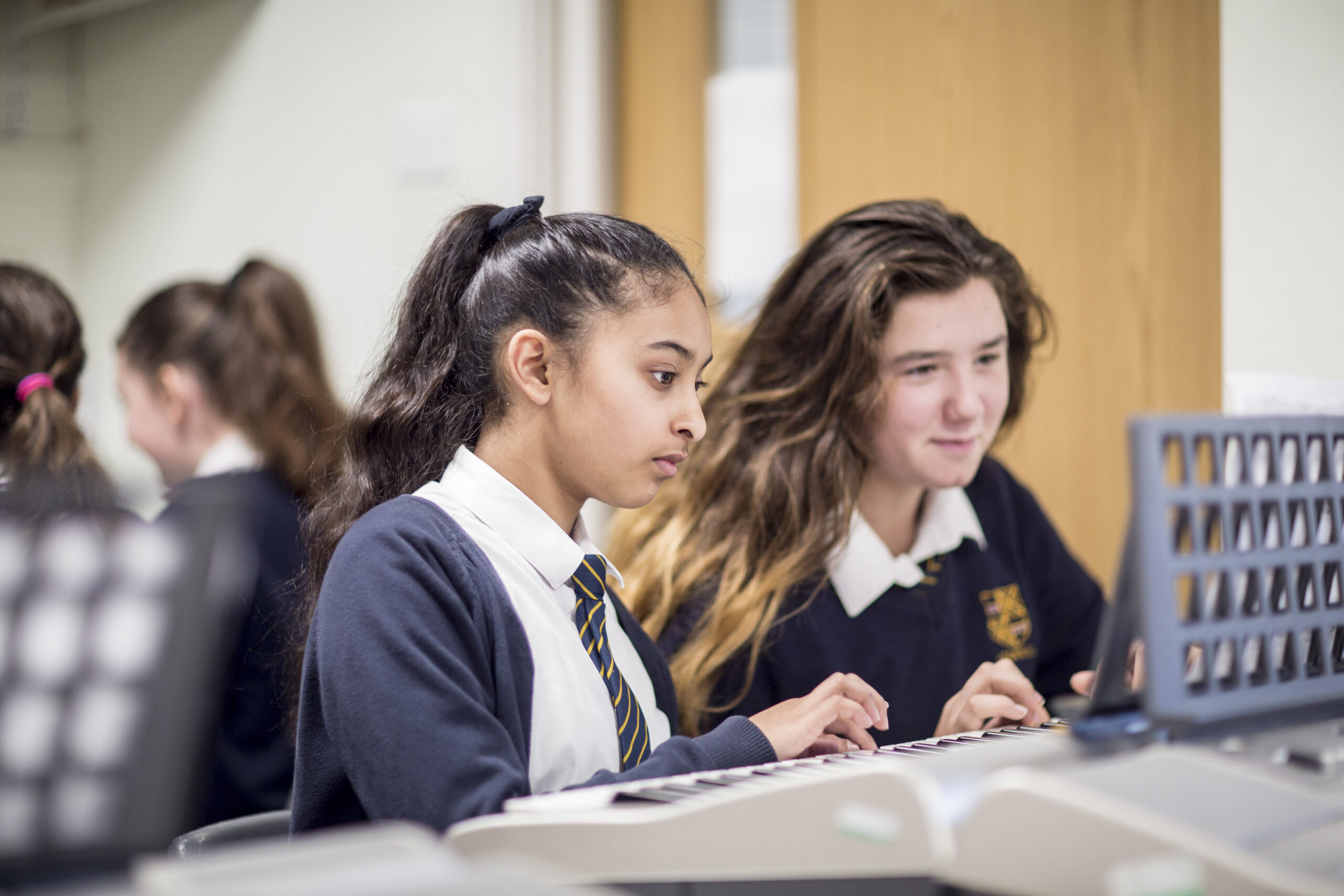 Two girls in black school uniforms working together.