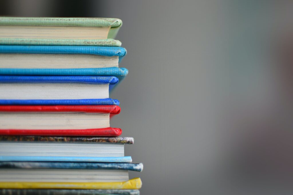 A pile of colourful textbooks seen from the side