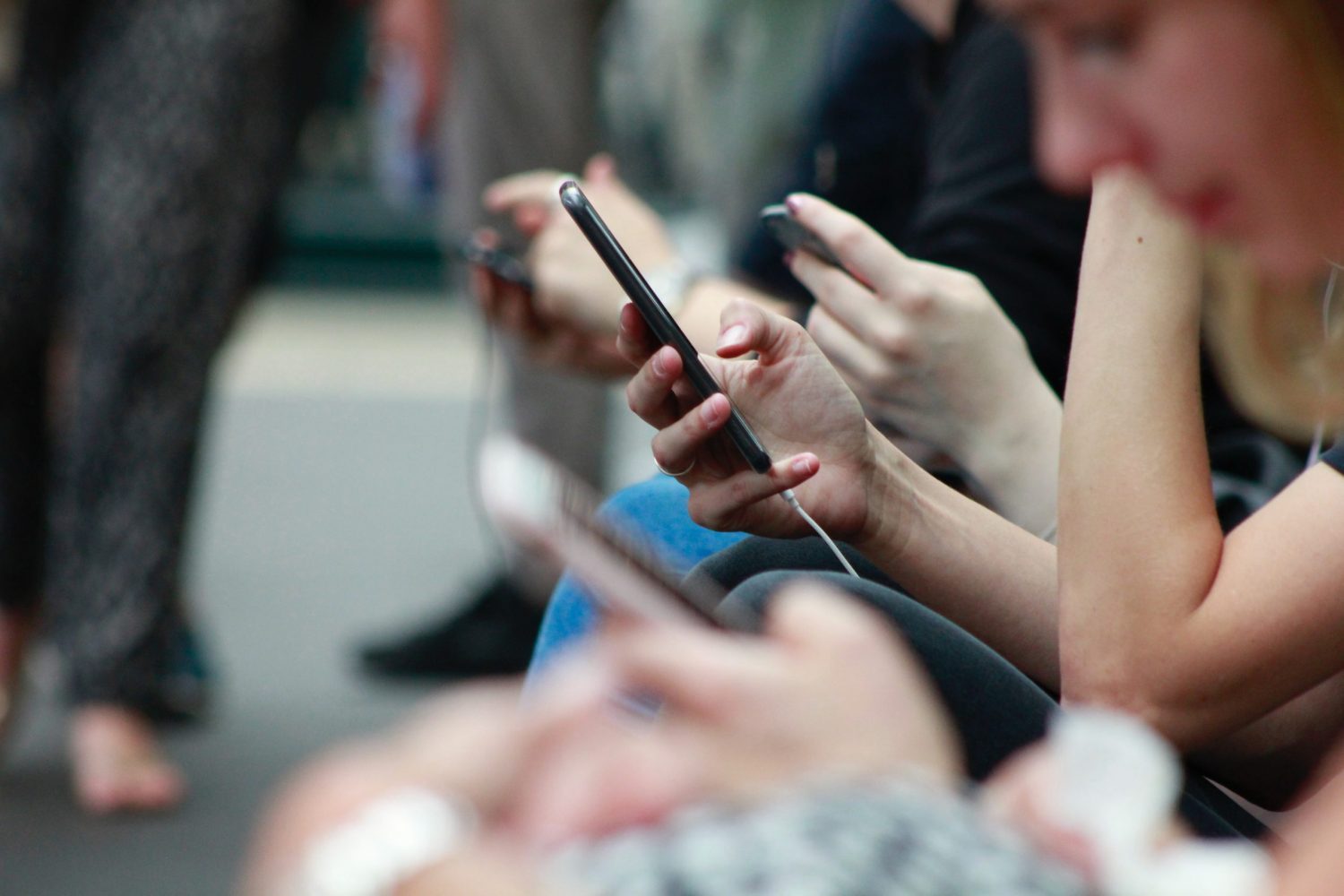 People scrolling down their phones in Bath, England.