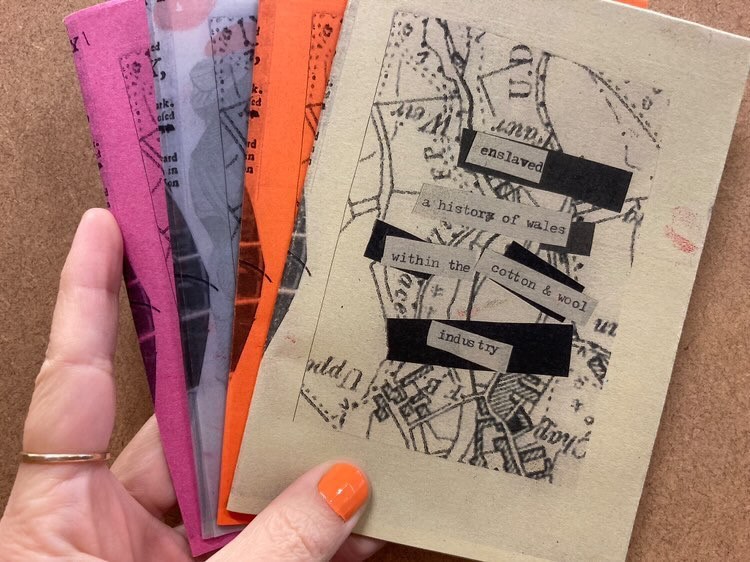 A person holding 4 different zines made by the students of Coleg Menai.